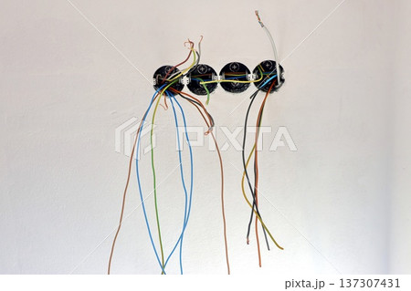 colorful cables hang from exposed electrical wiring boxes colorful cables hang from exposed electrical wiring boxes 137307431