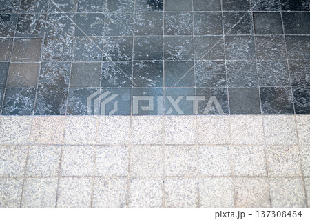 Worn square stone tiles with a geometric grid pattern visible texture and surface marks 137308484