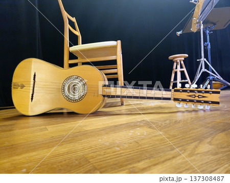 A handcrafted chitarra battente, a traditional Italian instrument, rests on the stage floor. 137308487