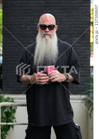Bald Man with Long White Beard Holding Coffee Outdoors 137308607