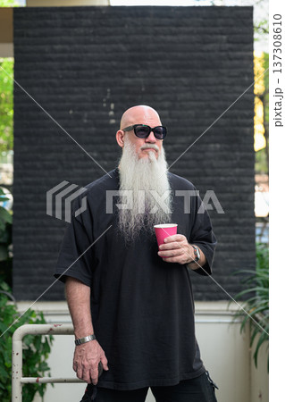 Bald Man with Long White Beard Holding Coffee Outdoors 137308610