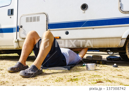 Man repairing bottom of the rv caravan Man repairing bottom of the rv caravan 137308742