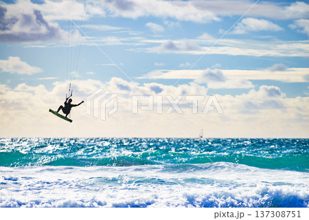Kite surfer riding waves. Kiteboarding sport. 137308751
