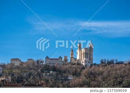 Lyon, france. December 27, 2023. Notre dame de fourviere basilica atop fourviere hill overlooking lyon skyline under a clear blue winter sky, historic landmark Lyon, france. December 27, 2023. Notre dame de fourviere basilica atop fourviere hill overlooking lyon skyline under a clear blue winter sky, historic landmark 137309039