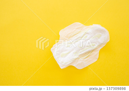 Women's sanitary napkin on a yellow background close-up Women's sanitary napkin on a yellow background close-up 137309898