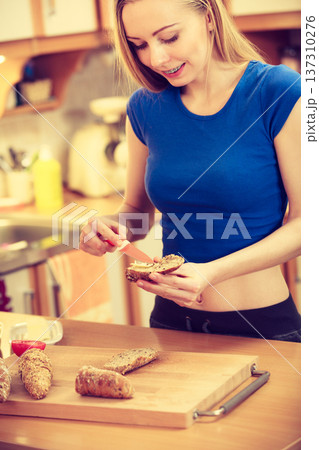 Woman preparing healthy breakfast making sandwich Woman preparing healthy breakfast making sandwich 137310276