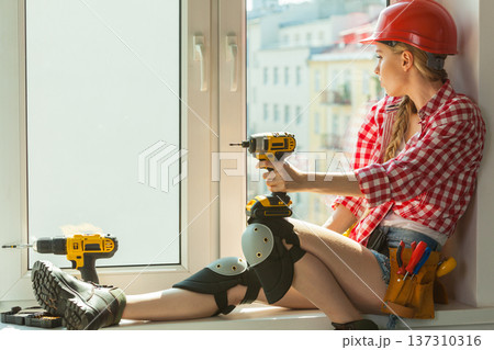 Woman with helmet next to the window Woman with helmet next to the window 137310316