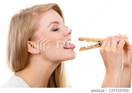 Blonde woman having tongue in clothespin Blonde woman having tongue in clothespin 137310760