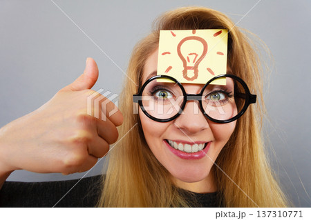 Woman having light bulb mark on forehead thinking 137310771