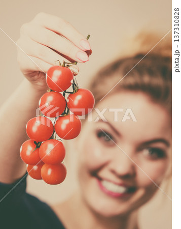 Woman holding fresh cherry tomatoes Woman holding fresh cherry tomatoes 137310828
