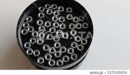 Heap Of Steel Nuts Inside Round Screw Box Closeup Angle View 137310859