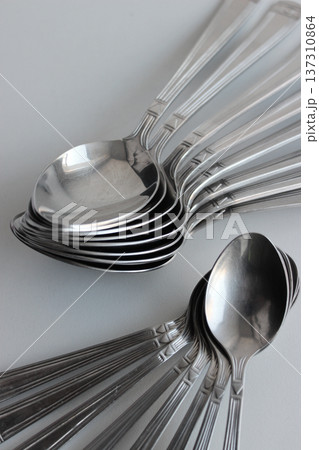 Eight tablespoons and eight teaspoons laid out in a fan shape isolated on white surface 137310864