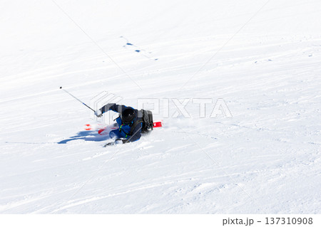 Male skiing downhill on snowy slope in winter sporting scene 137310908