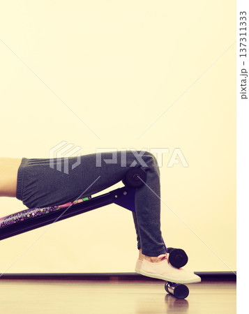 Woman training on bench for sit ups Woman training on bench for sit ups 137311333