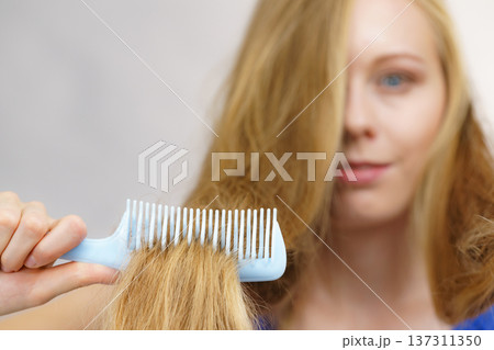 Woman combing long blonde hair Woman combing long blonde hair 137311350