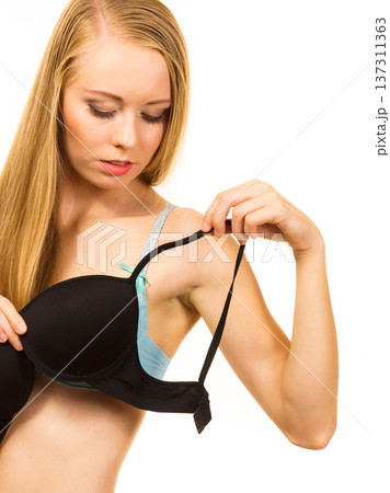 Woman trying on black bra Woman trying on black bra 137311363