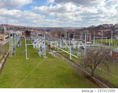 Electrical power substation infrastructure with transformer equipment cables and steel frames forming complex geometric industrial landscape. Energy distribution technology, electricity network 137311504