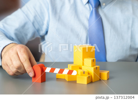 Boxes of goods and a barrier. Border control and customs regulation of trade supplies with import export restrictions and inspection procedures. 137312004