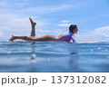 Woman Sitting On Surfboard Amid Breaking Wave Playful Beach Session 137312082