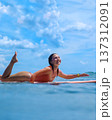 Serene Sky And Gentle Waves As Confident Woman Navigates Surfboard Skillfully 137312091