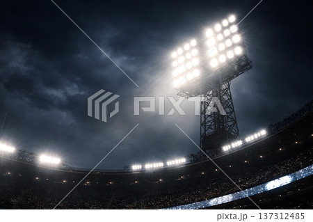 Powerful stadium floodlights illuminating a packed arena under a stormy night sky 137312485