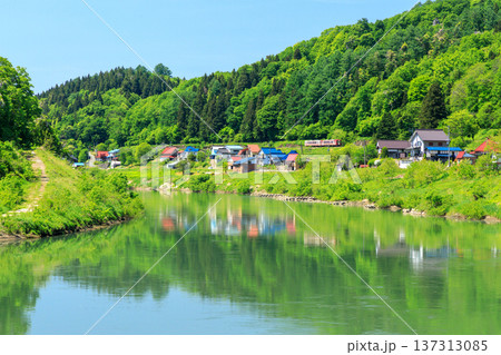 千曲川に寄り添う家々の側を抜ける飯山線の観光列車 千曲川に寄り添う家々の側を抜ける飯山線の観光列車 137313085