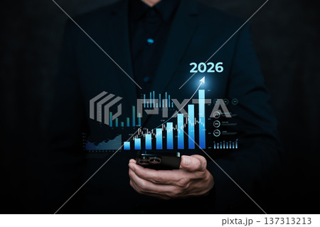 Businessman holding smartphone with digital financial chart and rising graph toward 2026, representing investment growth, fintech analytics, stock market trends, and future business success. Businessman holding smartphone with digital financial chart and rising graph toward 2026, representing investment growth, fintech analytics, stock market trends, and future business success. 137313213