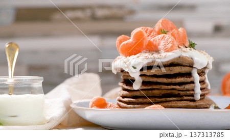 Stack of Buckwheat Pancakes Topped with Yogurt Cream and Fresh Mandarin Orange Segments Stack of Buckwheat Pancakes Topped with Yogurt Cream and Fresh Mandarin Orange Segments 137313785