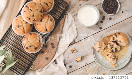 Fresh Baked Chocolate Chip Muffins on Cooling Rack with Milk and Crumbs Fresh Baked Chocolate Chip Muffins on Cooling Rack with Milk and Crumbs 137313791