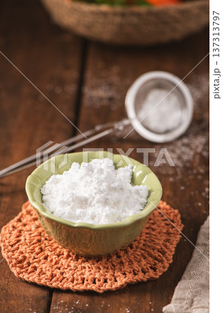 Fine Powdered Sugar in a Green Ceramic Bowl on a Rustic Wooden Table Fine Powdered Sugar in a Green Ceramic Bowl on a Rustic Wooden Table 137313797