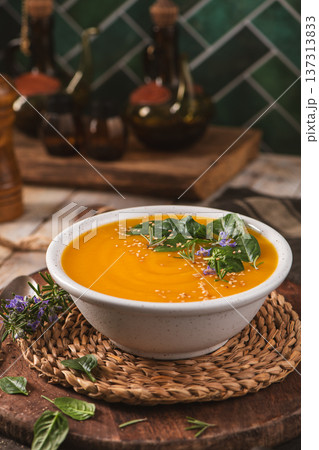 Creamy Butternut Squash Soup Topped with Fresh Basil Leaves and Rosemary Flowers 137313833