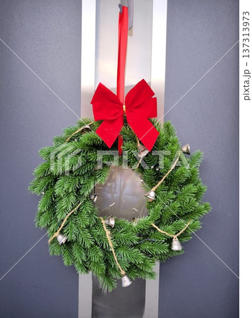 Christmas wreath made of fir branches with a red bow and bells Christmas wreath made of fir branches with a red bow and bells 137313973