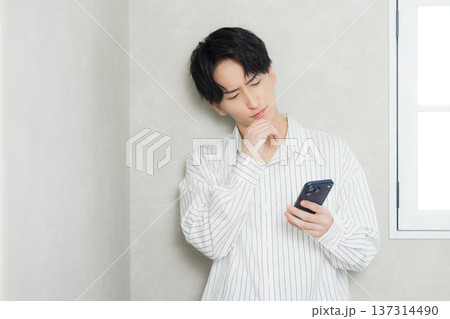 スマホを見る若い男性 137314490