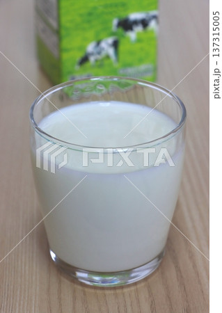 グラスに入った牛乳と牛乳パック（縦構図） 137315005