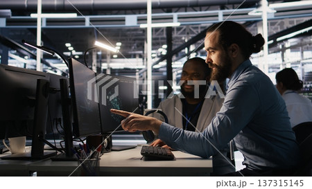 Lead data center engineer oversees team integrating AI automation tools during infrastructure maintenance. Worker under manager supervision uses machine learning models for operational tasks, camera A 137315145