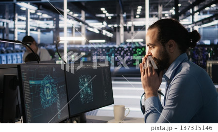 Overworked technician in data center managing server infrastructure for AI inference tasks. Fatigued employee using PC to maintain supercomputers running artificial intelligence tech, camera A Overworked technician in data center managing server infrastructure for AI inference tasks. Fatigued employee using PC to maintain supercomputers running artificial intelligence tech, camera A 137315146
