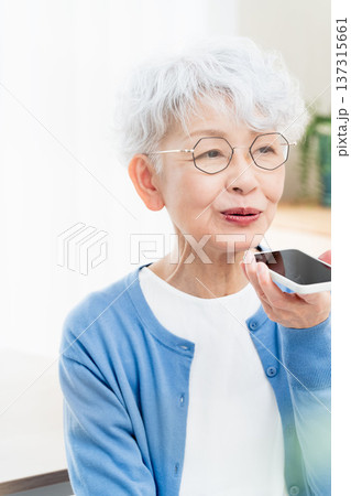 スマートフォンに話しかけるシニア女性 スマートフォンに話しかけるシニア女性 137315661