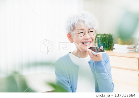 スマートフォンに話しかけるシニア女性 スマートフォンに話しかけるシニア女性 137315664