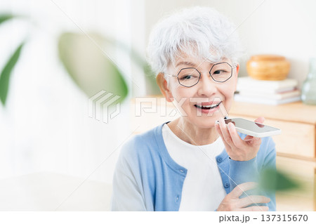 スマートフォンに話しかけるシニア女性 137315670