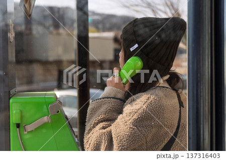 公衆電話をかける女性 公衆電話をかける女性 137316403