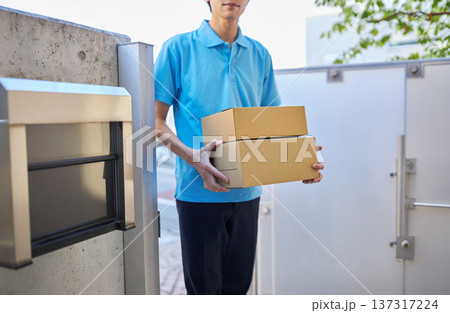 宅急便を自宅に届ける配送業者の男性 宅急便を自宅に届ける配送業者の男性 137317224