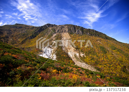 福島県、安達太良山の登山道からの紅葉。ごつごつした岩肌と赤や黄色の紅葉との共演が印象的で綺麗だ。 137317238