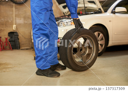 工場でタイヤ交換をする自動車整備士 137317309