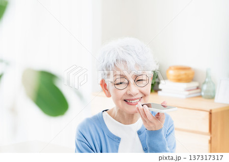スマートフォンに話しかけるシニア女性 137317317