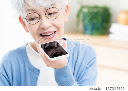 スマートフォンに話しかけるシニア女性 137317323