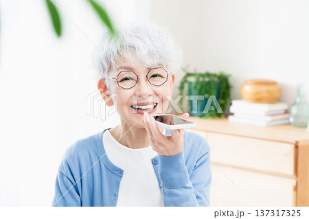 スマートフォンに話しかけるシニア女性 137317325