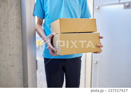 宅急便を自宅に届ける配送業者の男性 137317427