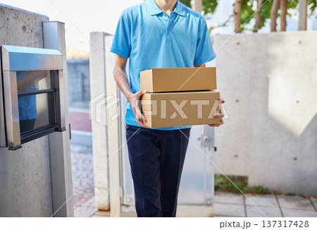 宅急便を自宅に届ける配送業者の男性 137317428