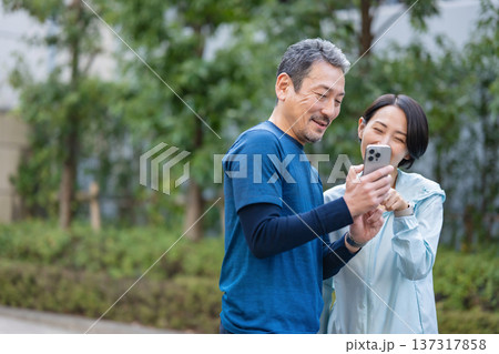 スマホを操作する夫婦 137317858