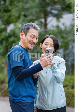 スマホを操作する夫婦 137317859
